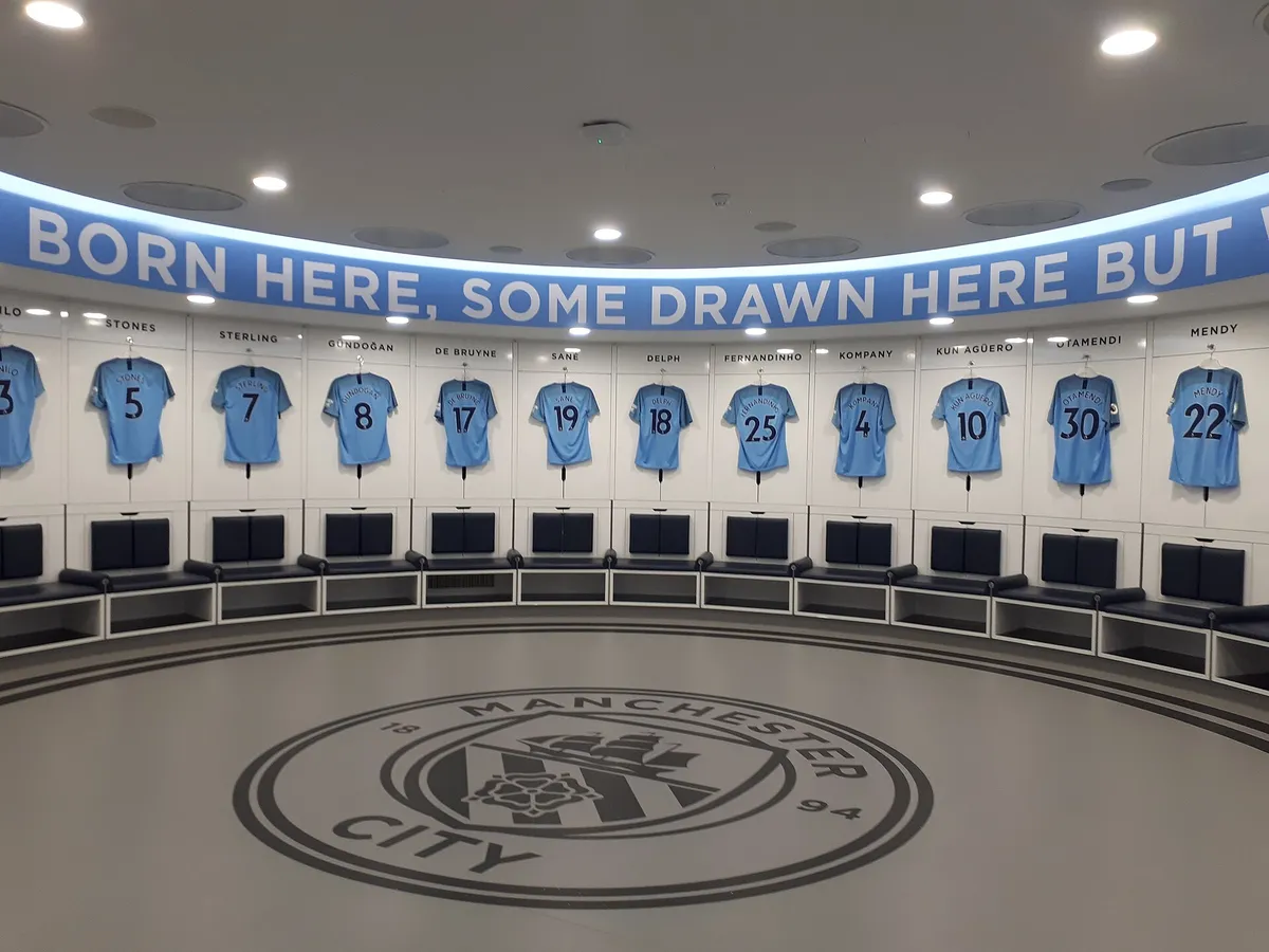 Real view of Manchester City's circular home dressing room with shirts displayed above the seats