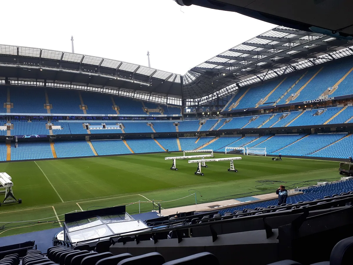 Real view across the Etihad Stadium pitch and pale-blue seating during a stadium tour